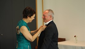 Susanne Hinzen heftet ihrem Nachfolger die Präsidentennadel an